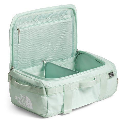 Open mint green duffel bag with interior compartments, mesh pocket in the lid, and "THE NORTH FACE" logo.