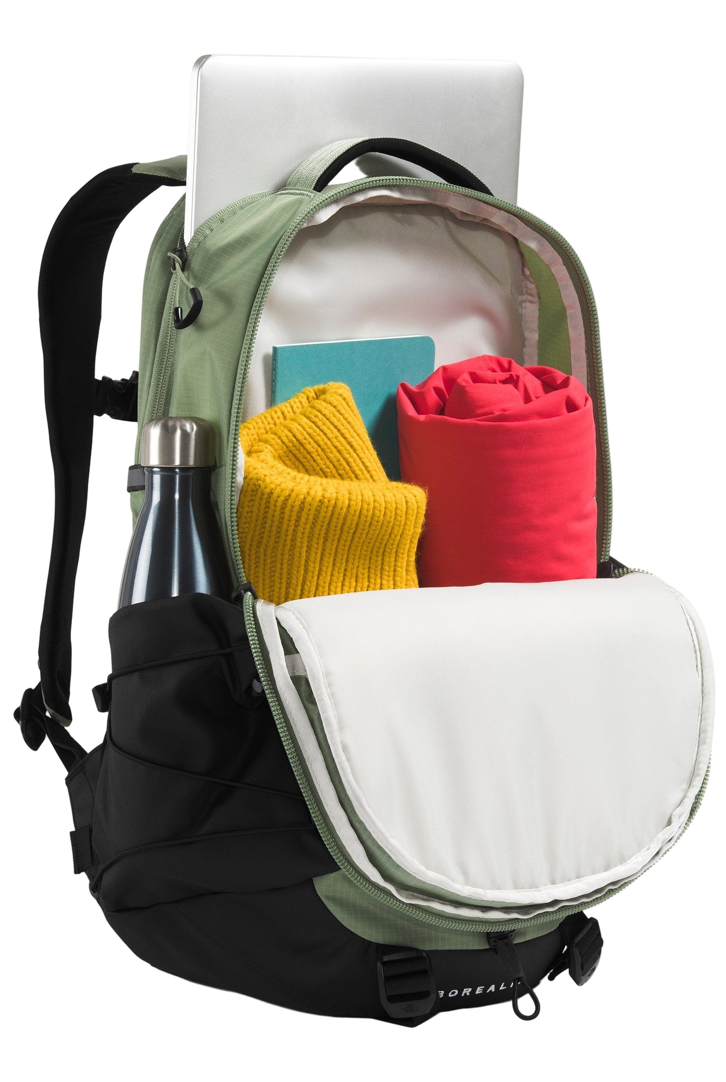 Open backpack with laptop, water bottle, notebook, yellow sweater, and red blanket.