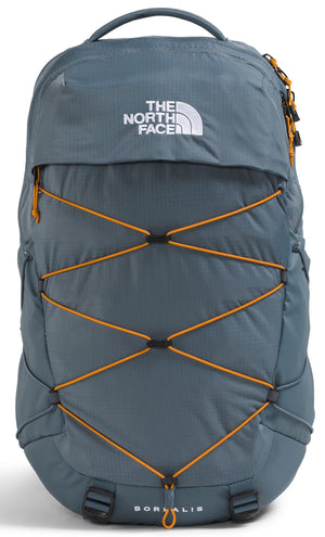 A gray North Face Borealis backpack with an orange bungee cord system on the front, featuring a white North Face logo on the top and the word Borealis printed near the bottom.