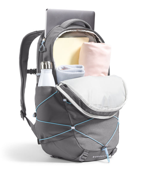 Gray backpack with blue bungee cord on the front, partially open to reveal rolled clothing and a laptop.
