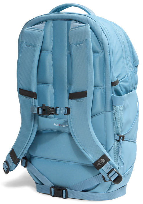 A light blue backpack viewed from the back, showing padded, contoured shoulder straps, an adjustable sternum strap with a buckle, a FlexVent logo on the back panel, and a bottom waist strap with a buckle.