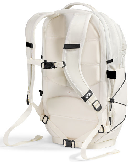 A light beige, off-white backpack shown from the back, featuring padded shoulder straps with a sternum strap, a top handle, a back panel with cushioned padding, and adjustable straps for securing the fit at the bottom and sides.