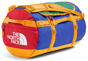 Duffel bag with red, blue, green, and gold panels. "The North Face" is printed in white on the red panel.