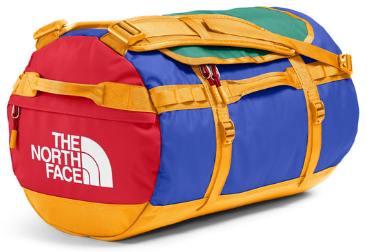 Duffel bag with red, blue, green, and gold panels. "The North Face" is printed in white on the red panel.