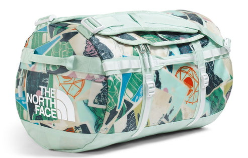 Mint-colored duffel bag with colorful geometric print, including The North Face logo.