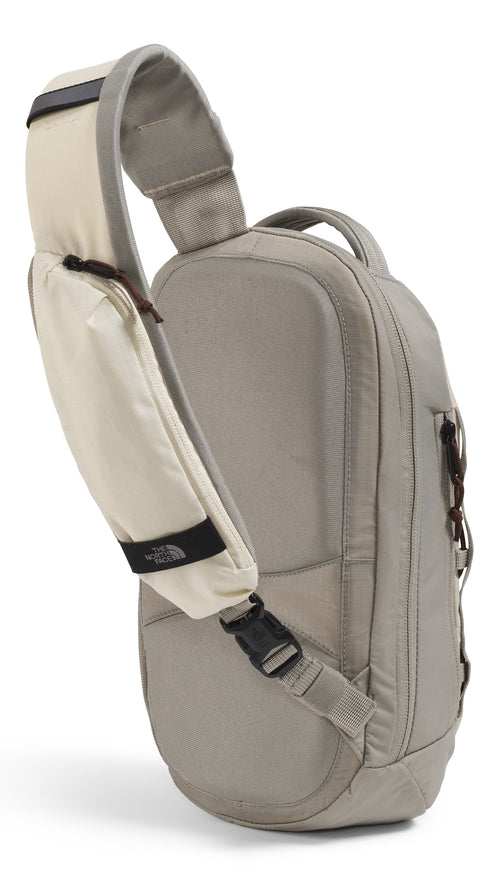 Tan sling backpack with wide shoulder strap.