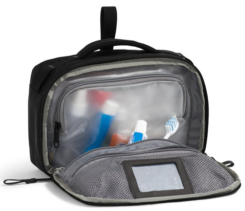 Open black toiletry bag revealing toothbrush, toothpaste, and other containers.