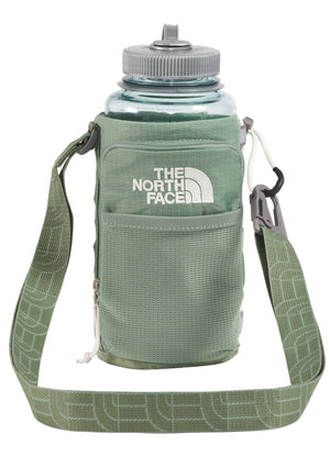 Green water bottle in a green carrier with a shoulder strap and the logo "THE NORTH FACE" on the front.