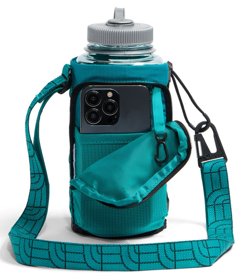 A teal water bottle carrying sleeve with an adjustable shoulder strap featuring a repeating line pattern, containing a clear water bottle with a grey lid and a dark smartphone held in an attached front pocket.