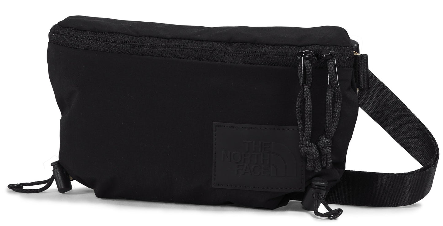Black belt bag with zipper closure, cord details, and strap.