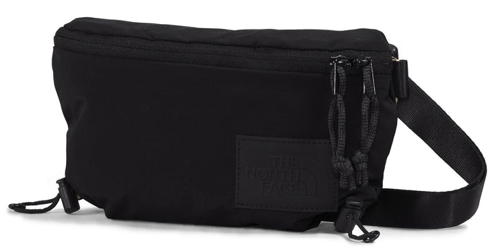 Black belt bag with zipper closure, cord details, and strap.