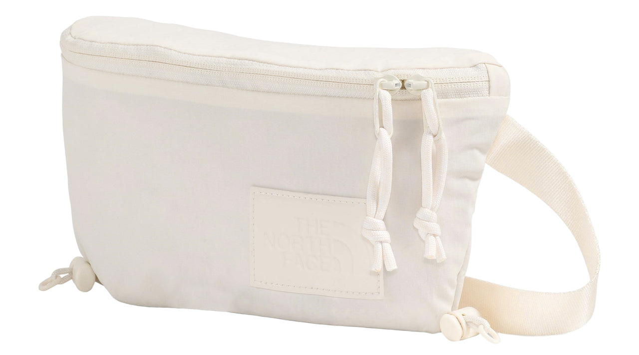 An off-white crossbody bag with a zipper closure and an adjustable strap.