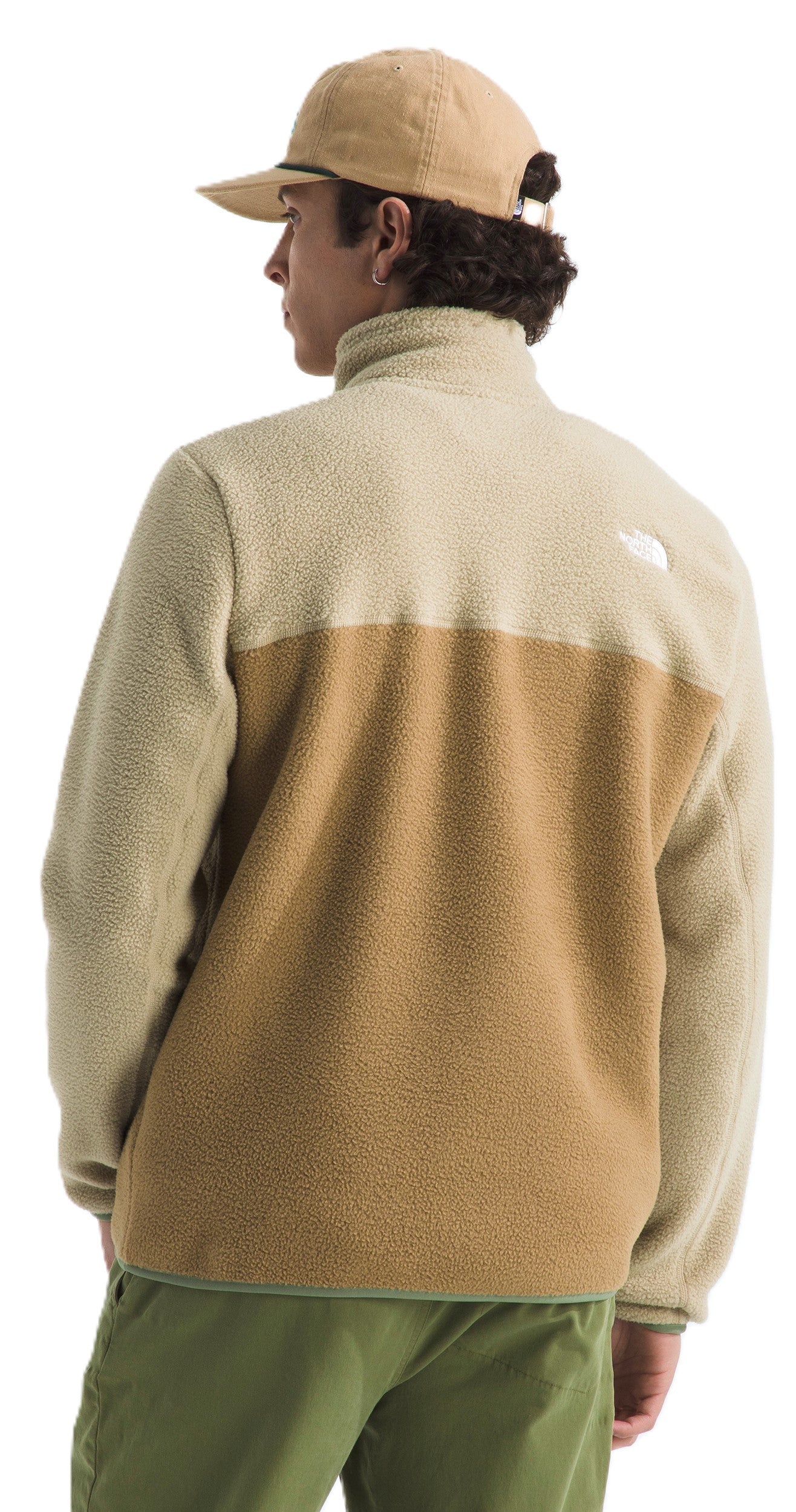 Person wearing a color-blocked fleece with a zipper and matching cap.