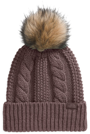 Knitted beanie hat with faux fur pompom on top and a cable knit pattern.