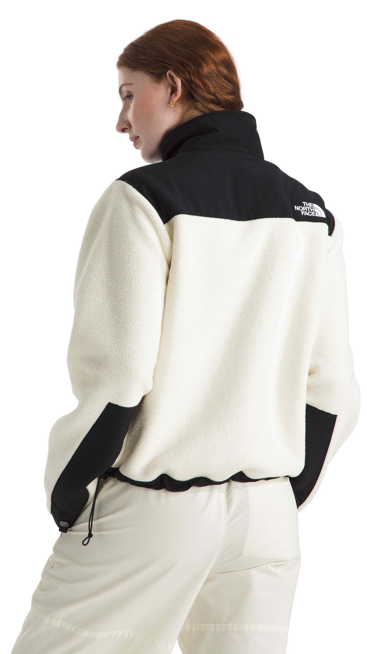 A woman wearing a white fleece jacket with black accents at the collar and sleeves.