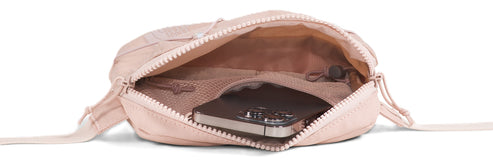A blush pink open handbag with a cell phone inside.