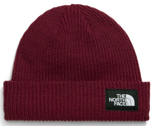A maroon, ribbed-knit beanie with a folded cuff and a rectangular black patch on the right side featuring white text reading 'THE NORTH FACE' and its logo.