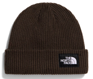 A dark olive green cuffed knit beanie with a square black fabric patch on the front featuring the white text "THE NORTH FACE" and its logo.