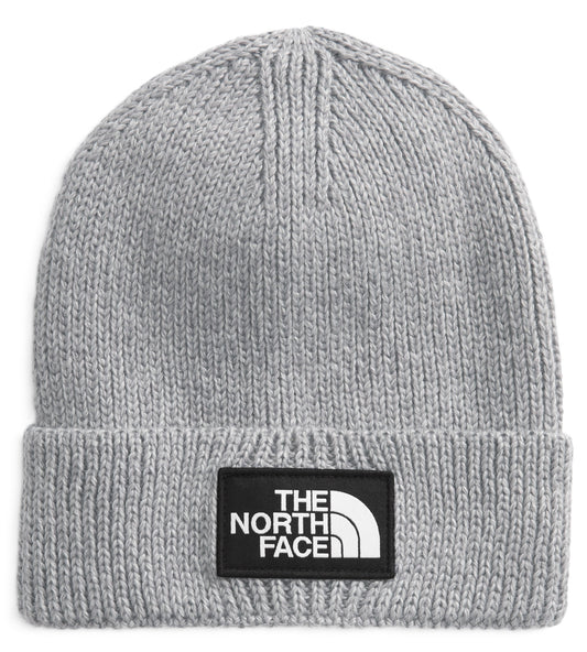 A light gray knit beanie with a black patch on the front that says THE NORTH FACE in white.
