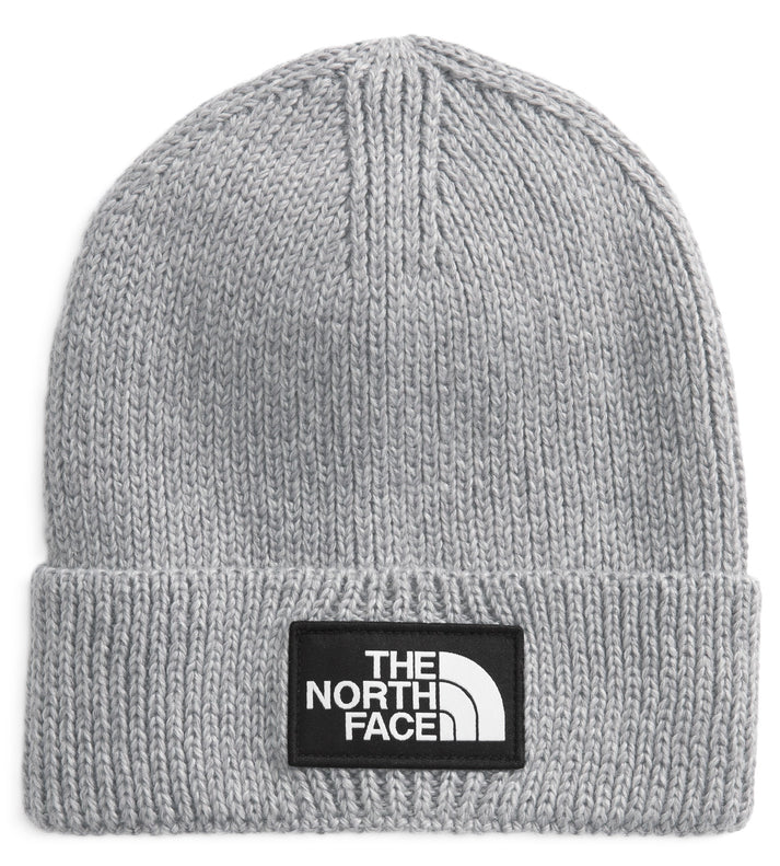 A light gray knit beanie with a black patch on the front that says THE NORTH FACE in white.
