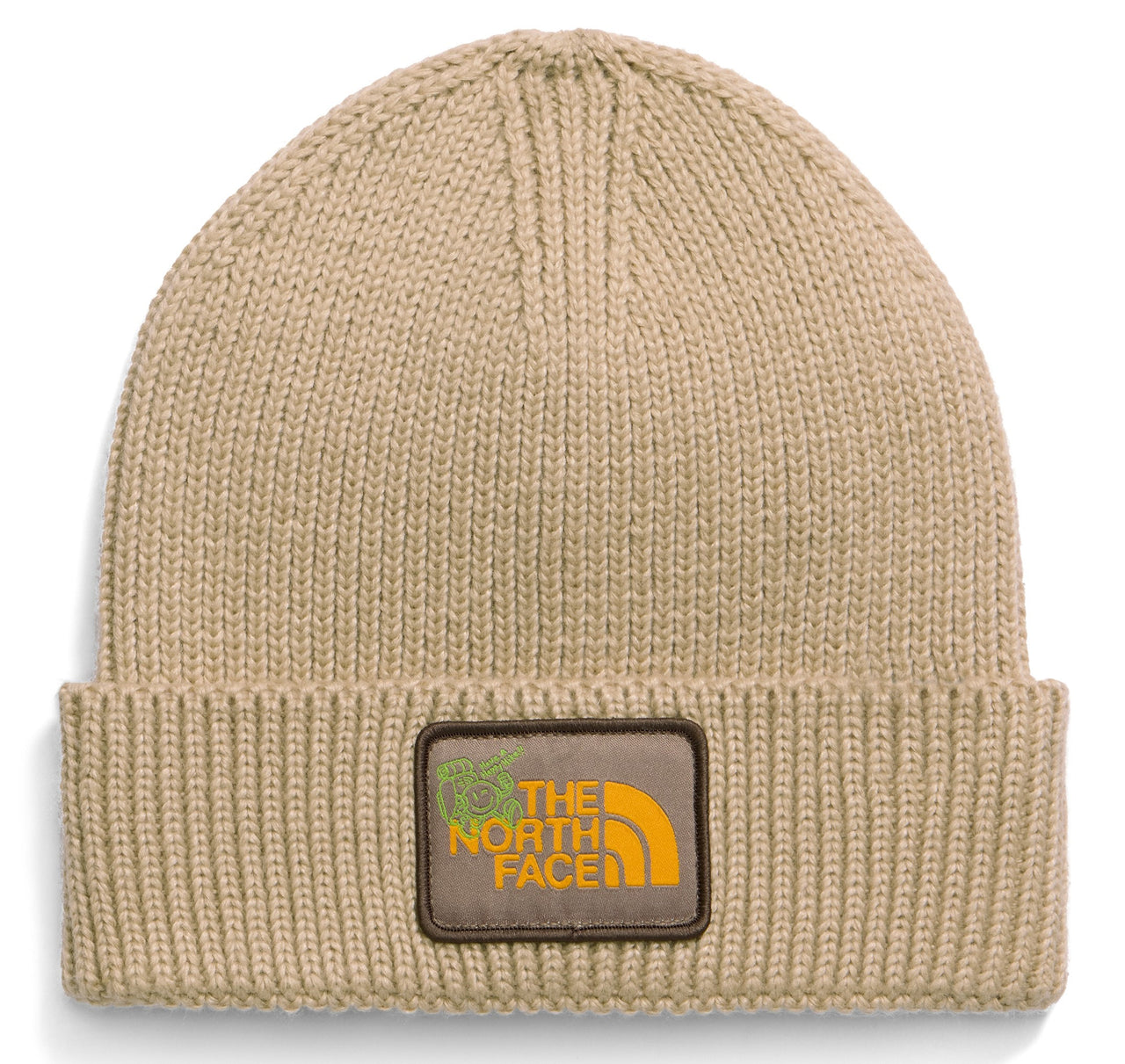 A tan knit beanie with a folded cuff featuring a brown rectangular patch with yellow text reading THE NORTH FACE and a small green graphic icon.