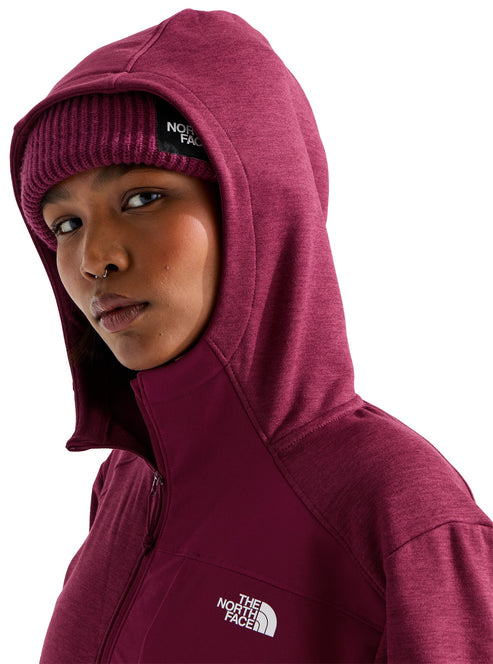 A person wearing a dark maroon hooded jacket over a matching knitted beanie, with "THE NORTH FACE" logo visible on the beanie and the chest of the jacket.