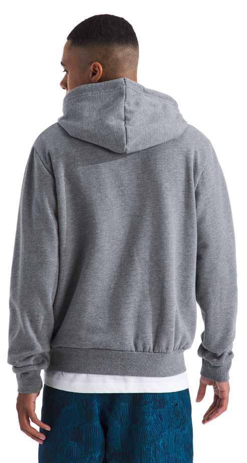 Back view of a person wearing a gray hooded sweatshirt over a white t-shirt, and blue pants.