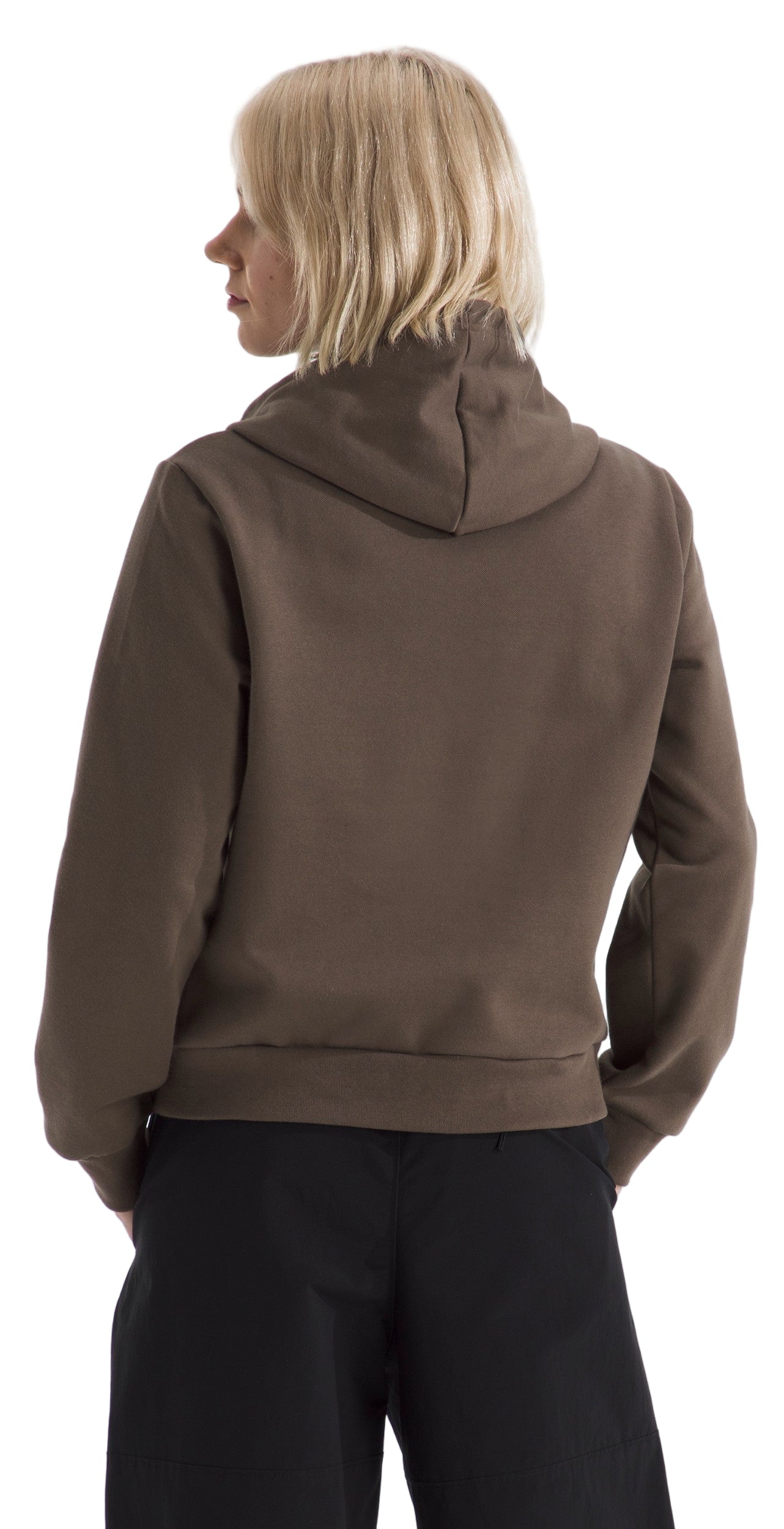 Woman wearing a brown hoodie with black pants, facing away from the camera.