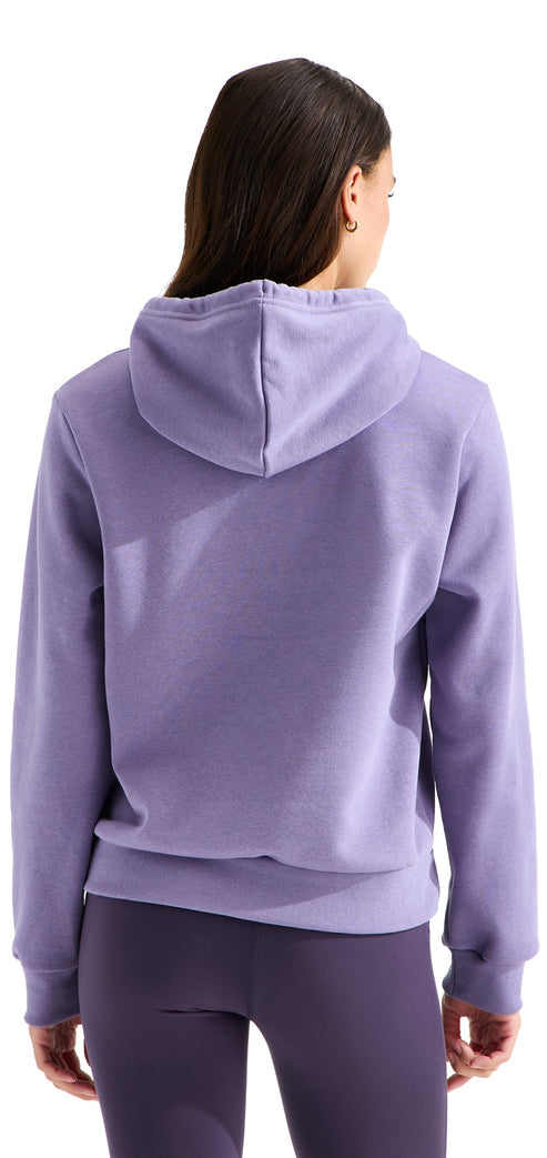 A back view of a woman wearing a light purple hooded sweatshirt and dark purple leggings.