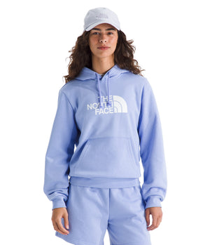 A woman wearing a light blue hoodie with white text that reads THE NORTH FACE, and a light blue baseball cap.