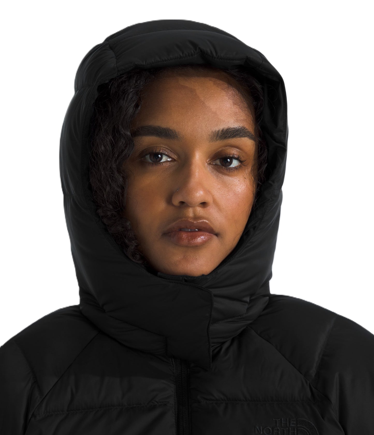 Close-up of a model wearing a black hooded puffer jacket.