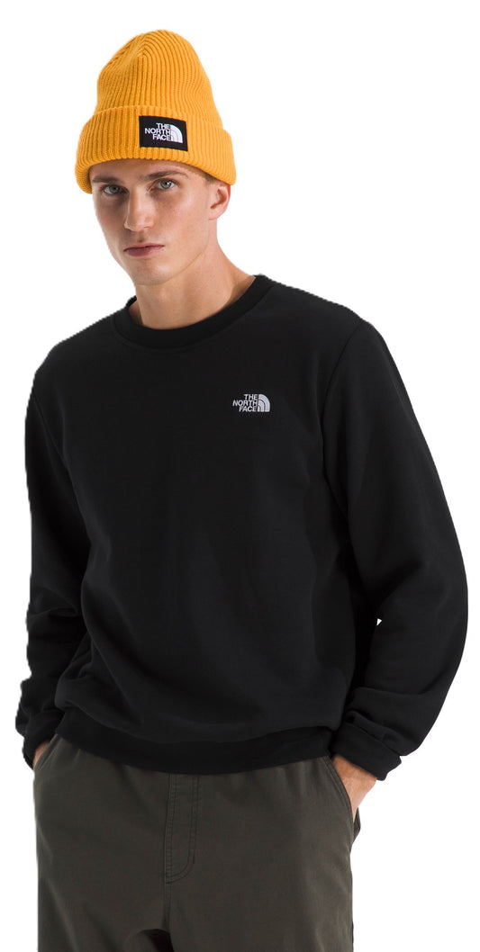 A person wearing a black sweatshirt with a white logo on the upper-left, and a yellow beanie.