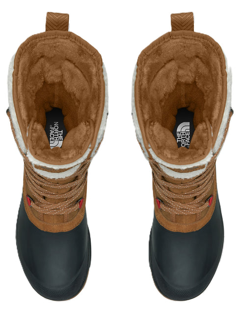 A top-down view of a pair of brown and black winter boots with fur-lined collars and The North Face branding inside.