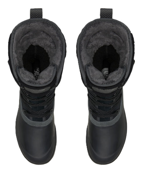 A top-down view of a pair of black, calf-height winter boots with a fuzzy, dark grey faux-fur lining, lace-up fronts, and rounded toes.