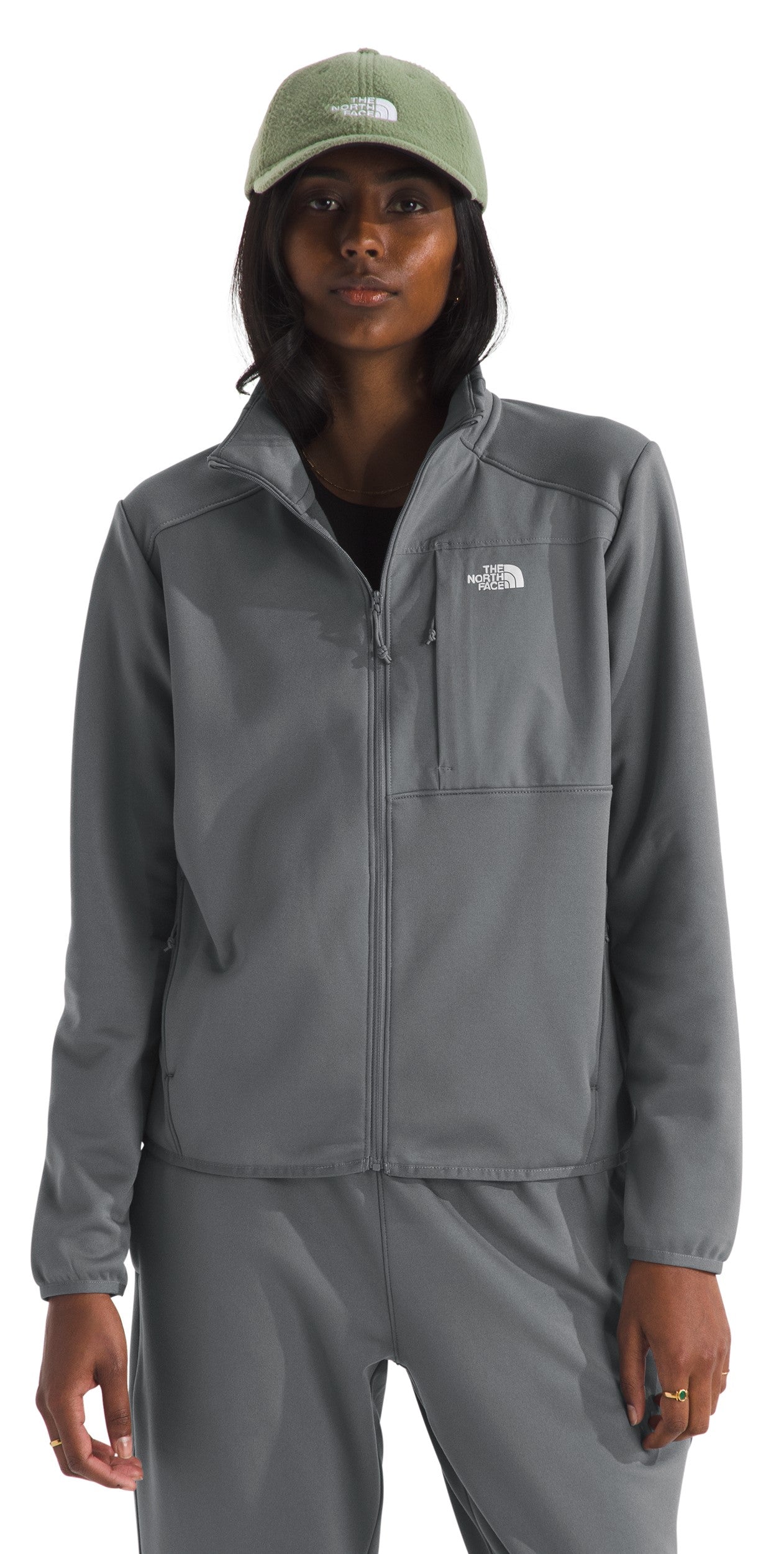 Person wearing a grey full-zip jacket with a breast pocket and a green cap.