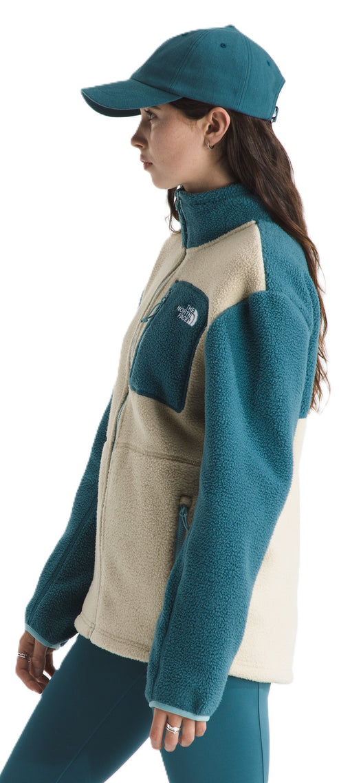 A woman wearing a cap and a fleece jacket with a zipper.