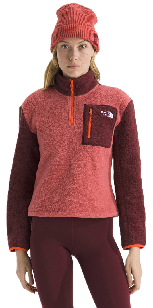 A person wearing a red beanie, a two-tone pink and burgundy fleece pullover, and burgundy leggings.