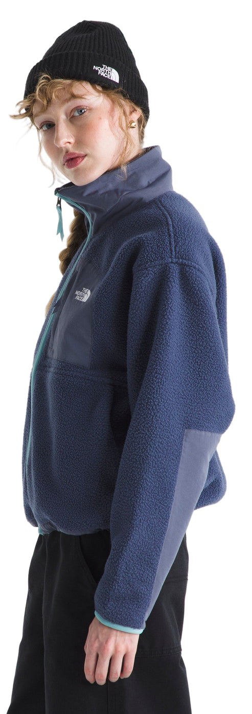 A person wears a navy fleece jacket with a black beanie. 