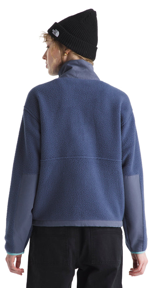 Back view of a woman wearing a blue fleece jacket and black beanie.