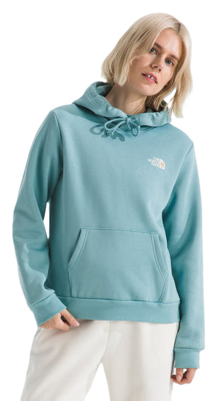 A woman wearing a light blue hoodie with a front pocket and a white logo on the chest.