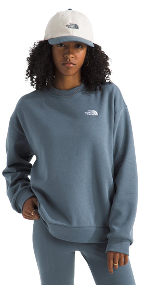 Person in a slate blue sweatshirt and leggings with a baseball cap.