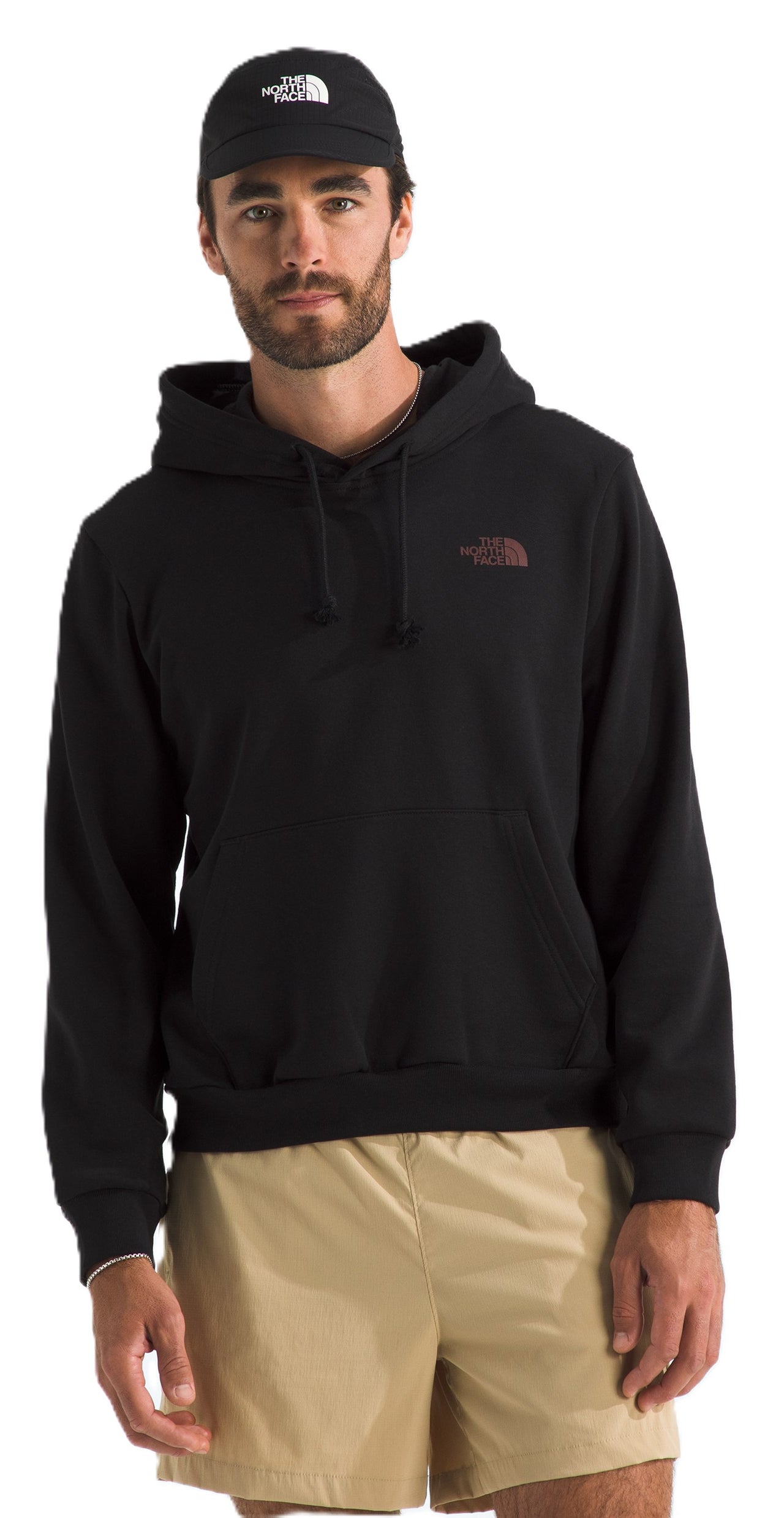 A man wearing a black hoodie and khaki shorts with a black cap.