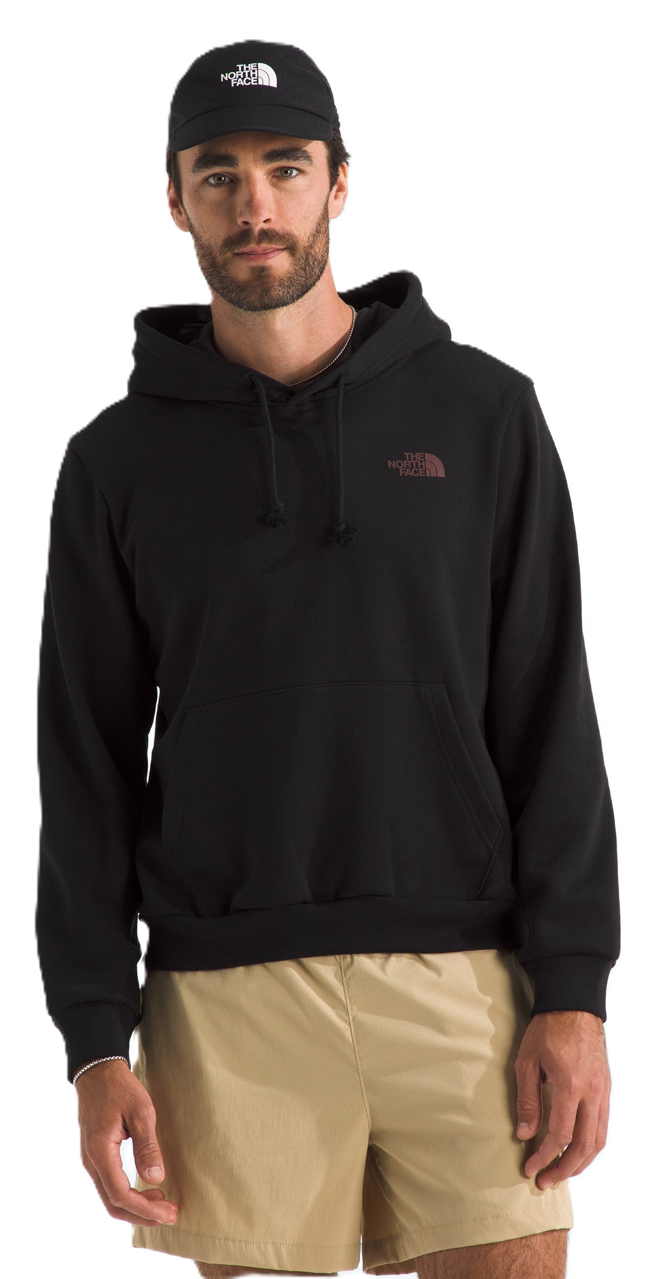 A man wearing a black hoodie and khaki shorts with a black cap.