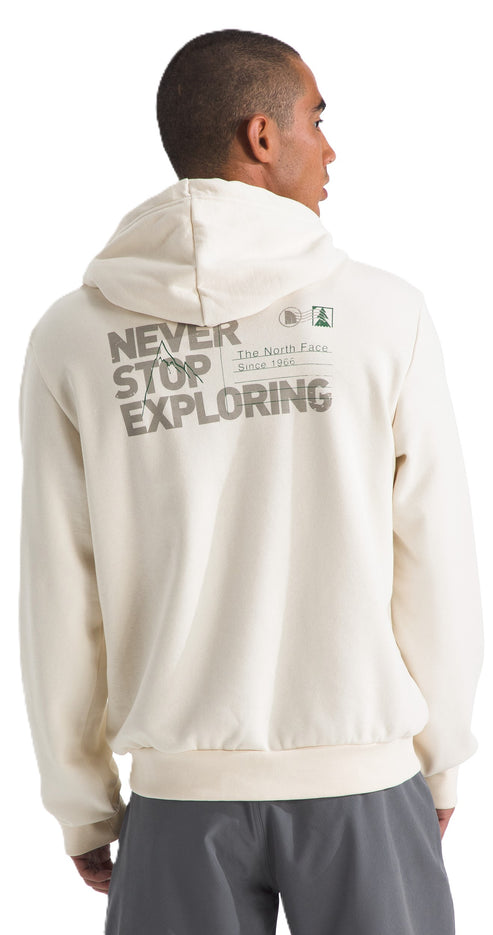 A person viewed from the back wearing an off-white hoodie with the text "NEVER STOP EXPLORING" printed on the back along with "The North Face" and "Since 1966".
