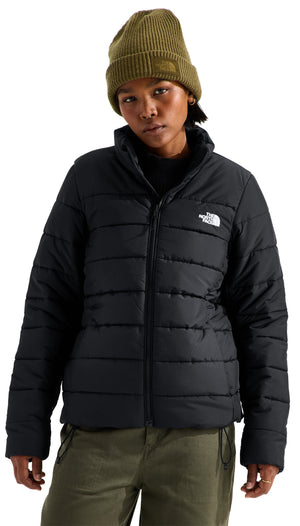 A person wearing a black, quilted, insulated puffer jacket with a front zipper and an olive green knit beanie.