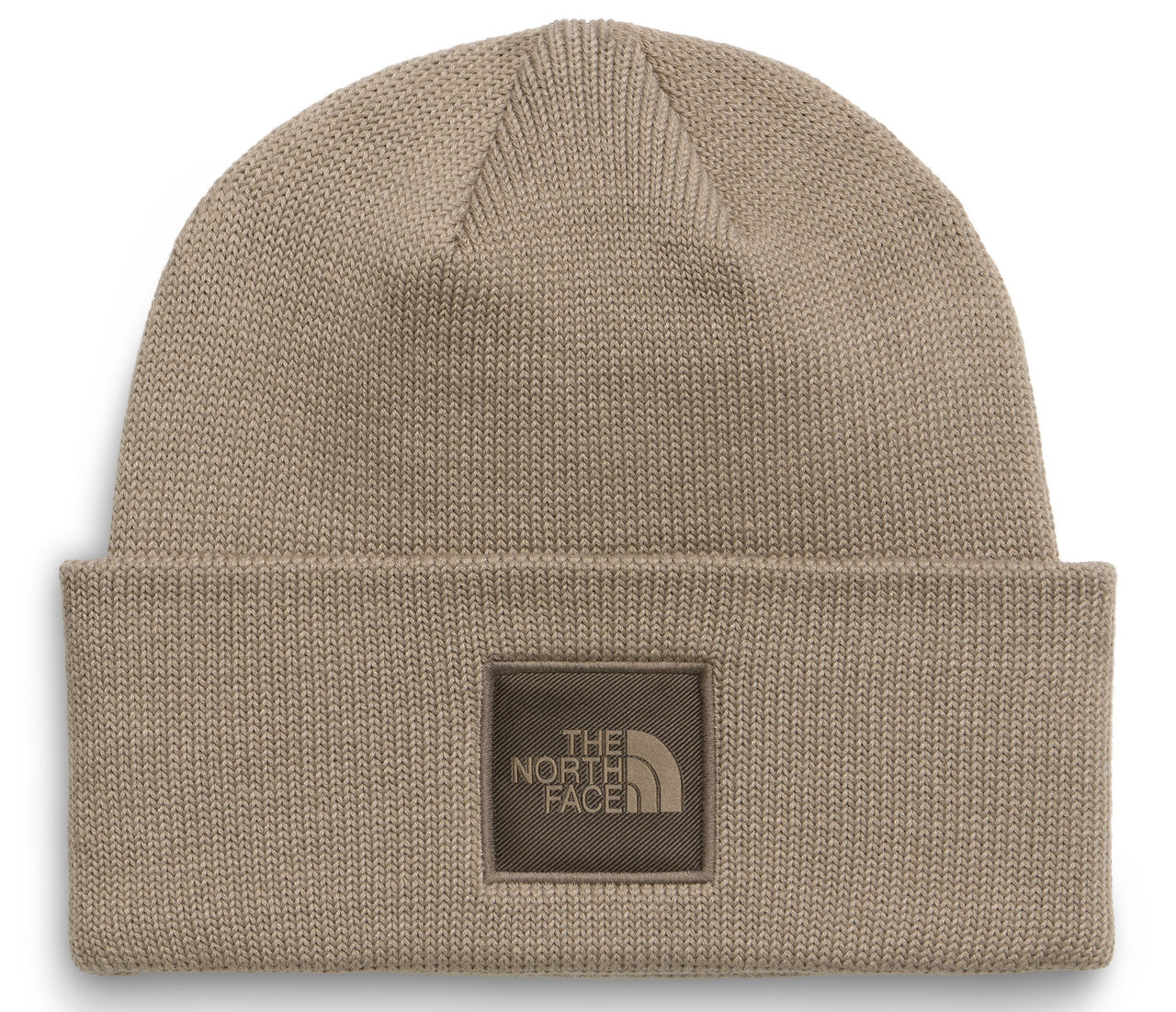 A tan knit cuffed beanie with a square brown patch centered on the cuff featuring the words 'THE NORTH FACE' and a logo icon in a darker brown color.