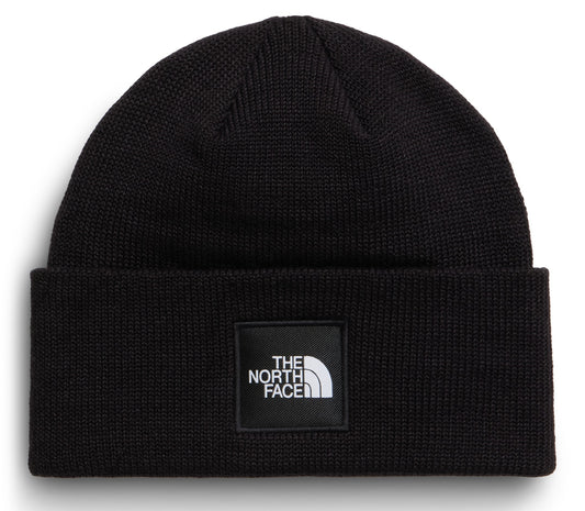 A black knitted beanie featuring a square patch on the front with the text "THE NORTH FACE" in white.