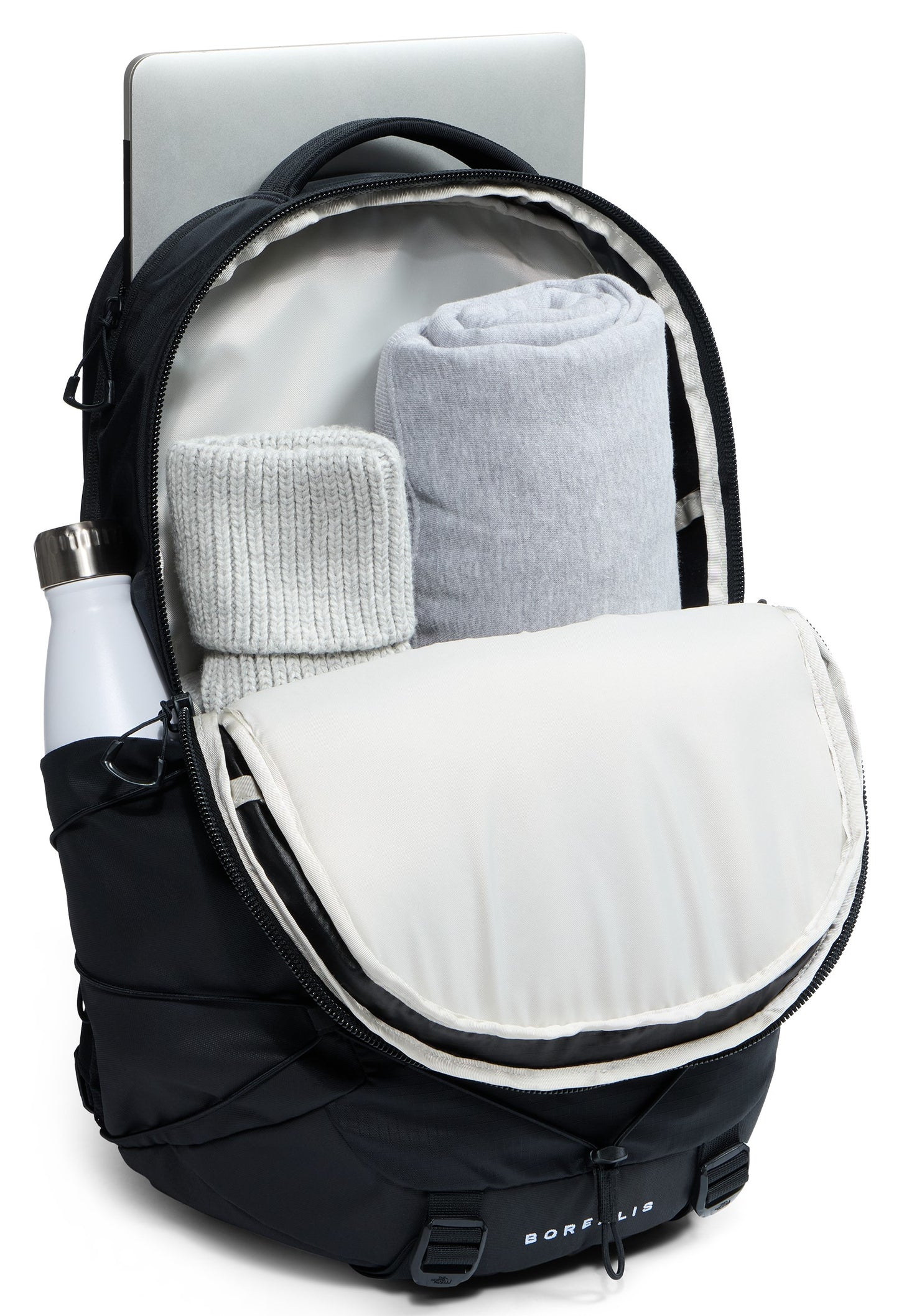 A black backpack with its main compartment open, revealing two rolled-up gray blankets inside, a laptop partially inserted into a dedicated sleeve at the back, and a white water bottle secured in the side pocket.