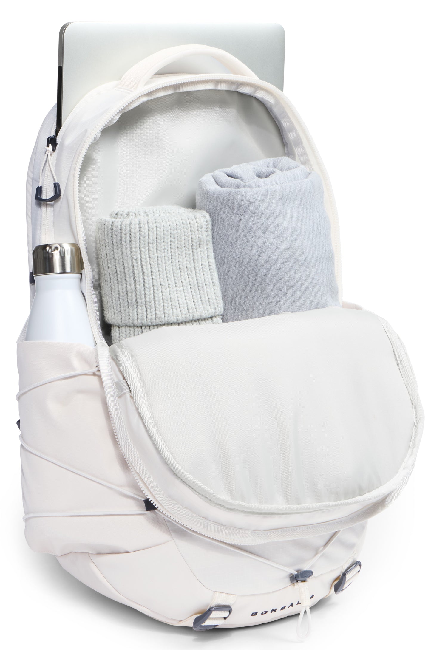 A white backpack open to reveal two rolled-up items inside, with a laptop partially protruding from the back compartment and a water bottle in the side pocket.