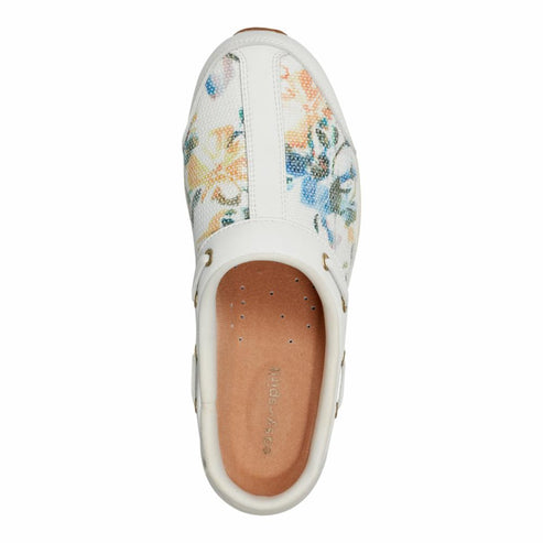 Top-down shot of a white slip-on shoe with floral print, white trim, and brown insole.